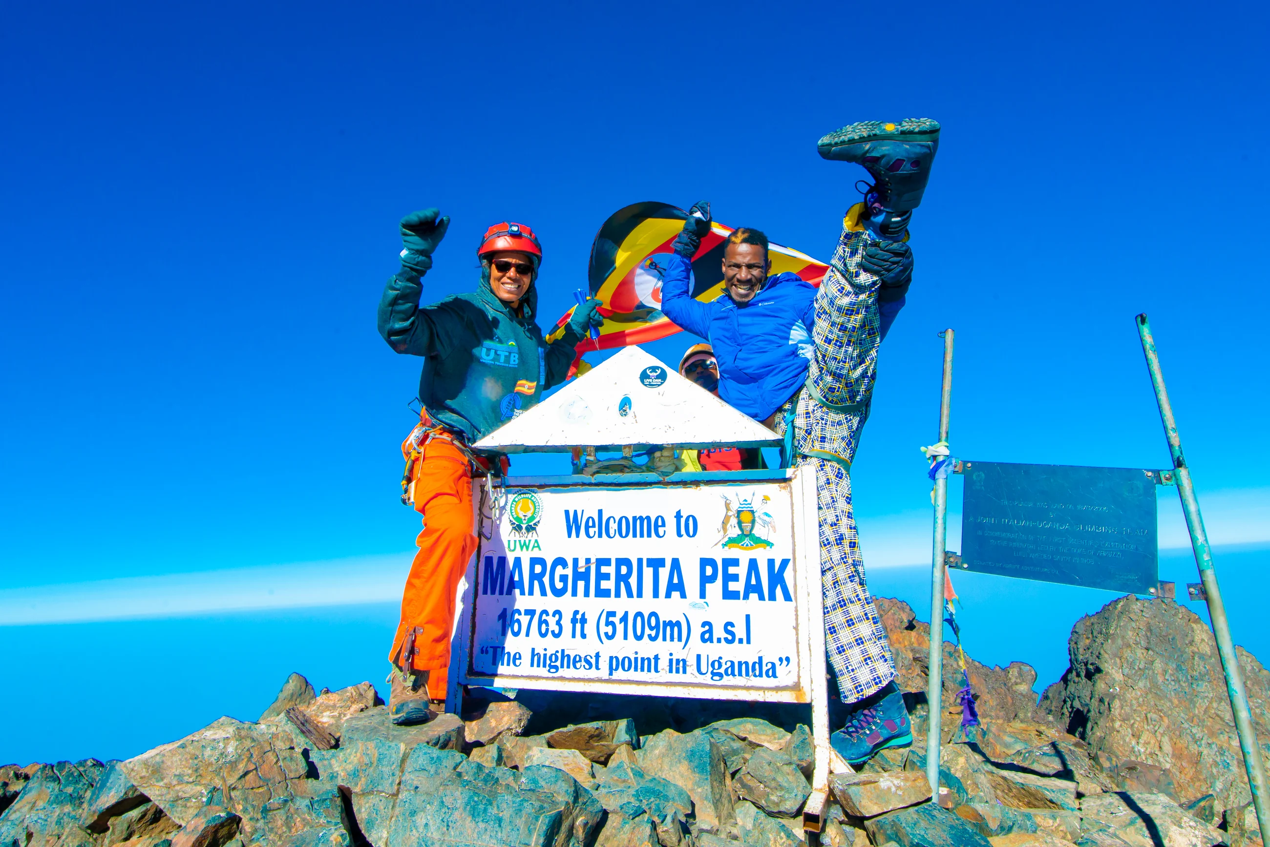 Climbers at the Margherita Peak summit sign, 5,109m and the highest point in Uganda, on the 9 Days Rwenzori Margherita Peak Trek